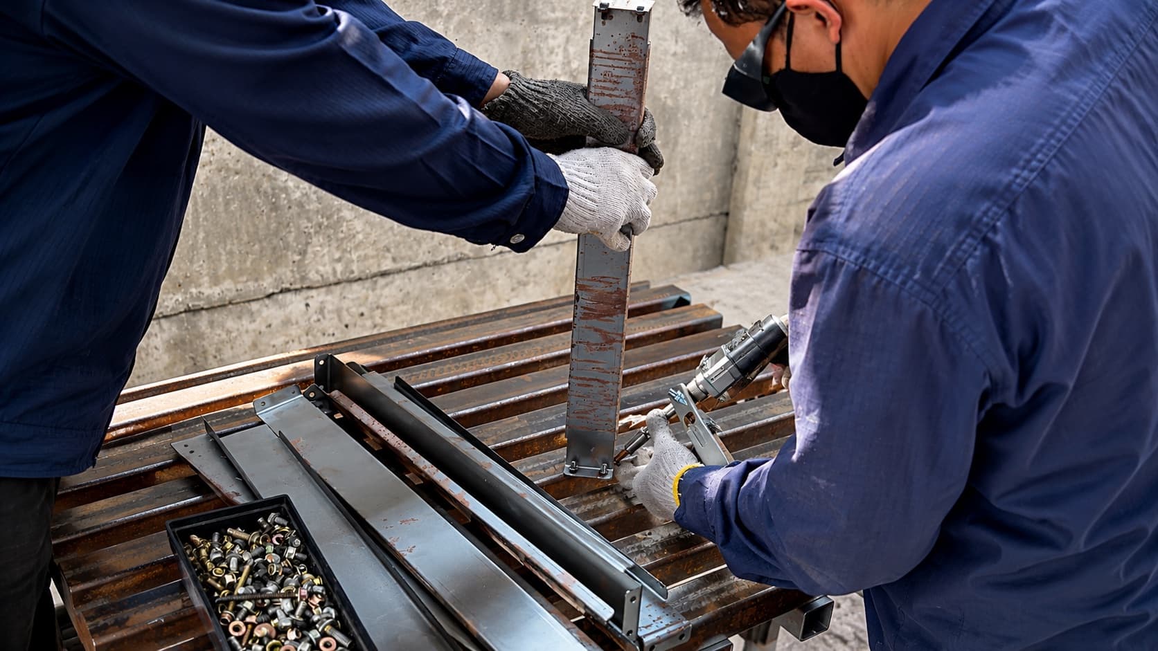 Technician handling metal stock at a production machine